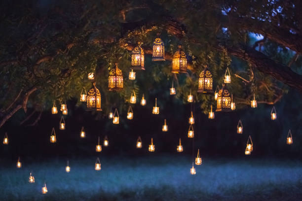 Night wedding ceremony with a lot of vintage lamps and candles on big tree